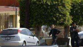 Policías municipales resguardan la zona donde dos escoltas fueron asesinados por una presunta víctima de secuestro.