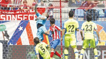 Diego (centro) toma un rebote del larguero y con golpe de cabeza bate  a Moyá para anotar el segundo gol de Atlético de Madrid sobre Getafe.