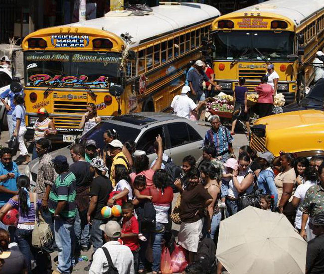 Decenas de viajeros hacen fila para tomar un autobús e iniciar su descanso de Semana Santa en Tegucigalpa (Honduras).