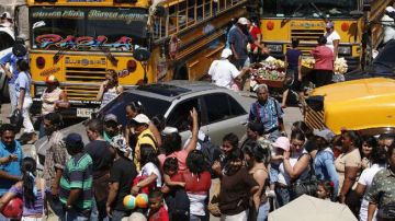 Decenas de viajeros hacen fila para tomar un autobús e iniciar su descanso de Semana Santa en Tegucigalpa (Honduras).