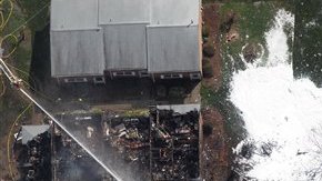 Los bomberos se mantienen apagando el incendio provocado por el accidente de la nave militar en Virginia Beach.