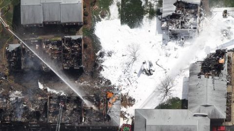 Los bomberos se mantienen apagando el incendio provocado por el accidente de la nave militar en Virginia Beach.