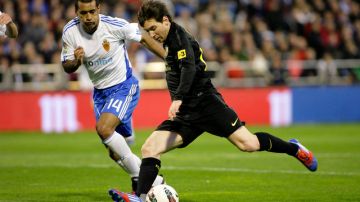 Lionel Messi (der.) defiende el  esférico ante  Paulo da Silva, del Zaragoza.