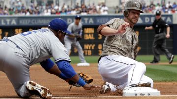 Juan Uribe (izq.), tercera base de Dodgers,  toca tarde a Chase Headley.