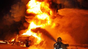 Los bomberos tratan de apagar las llamas del camión cisterna que se encendió el sábado en la autopista 134, cerca de la 5.