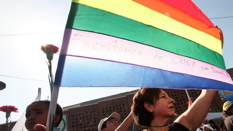 Una mujer sostiene una bandera arco iris en el funeral de Daniel Zamudio, en Santiago, Chile.