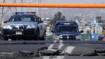 Varios vehículos de la policía bloquean el paso en un puente que resultó afectado durante el temblor de 7.4 grados Richter. ocurrido el pasado 20 de marzo en México.