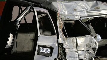 El cuerpo cubierto de una víctima yace a un lado de una camioneta luego de un accidente mortal de una camioneta que transportaba inmigrantes.