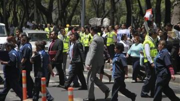 Oficinistas son evacuados durante un temblor en la ciudad de México.