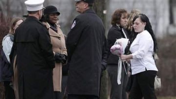 Bobbie Kugler, de blanco, a la derecha, lucía sumamente apesadumbrada en los funerales de los menores.
