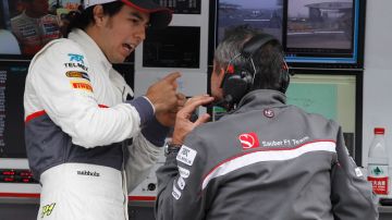 Sergio Perez (izq.) habla con uno de los mecánicos de la Sauber.