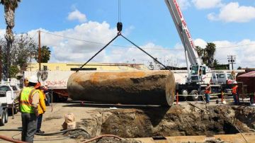 Trabajadores de la EPA retiran un tanque abandonado de 10 mil galones como parte de un proyecto piloto de limpieza ambiental.