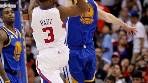 Chris Paul (3)  tira a la canasta pese al acoso Klay Thompson.