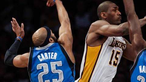 Metta World Peace (centro) intenta disparar al aro, a pesar del acoso de  Vince Carter (izq.), e Ian Mahinmi, ayer,  en el Staples Center.