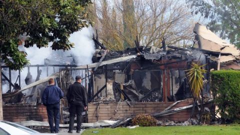 Los bomberos inspeccionan el edificio de apartamentos de Modesto donde se encontró el cuerpo calcinado del hombre que aparentemente mató a un agente del sheriff y a un civil.