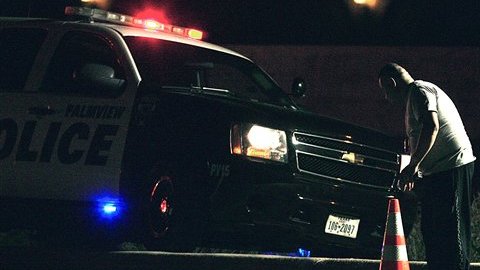 Un policía mira el cuerpo de uno de los migrantes fallecidos en el accidente.