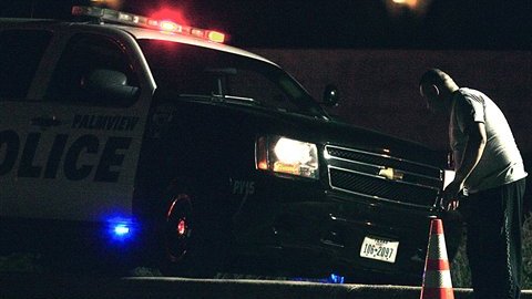 Un policía mira el cuerpo de uno de los migrantes fallecidos en el accidente.