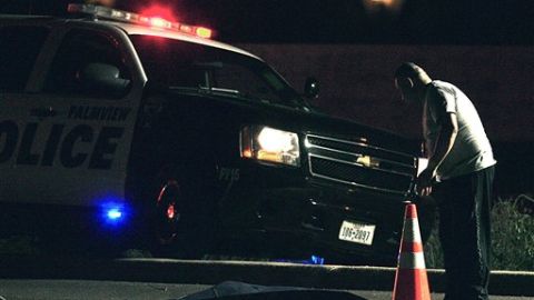 Un policía mira el cuerpo de uno de los migrantes fallecidos en el accidente.