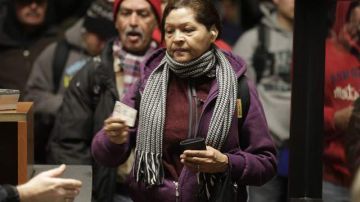 Una mujer muestra su identificación a las autoridades en el cruce fronterizo de camino a Mexicali, donde labora a diario.