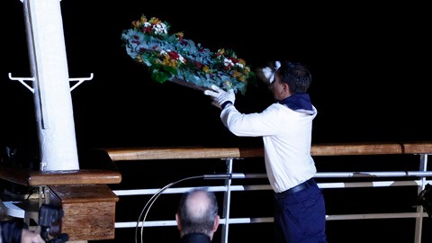 Un miembro de la tripulación del MS Balmoral Titanic arroja una corona de flores  durante una ceremonia conmemorativa, con motivo del 100 aniversario  del desastre del Titanic, en el lugar del naufragio en el Océano Atlántico.