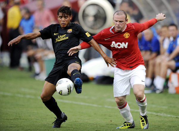 Jonathan dos Santos (izq.) aquí ante Wayne Rooney del Manchester United.