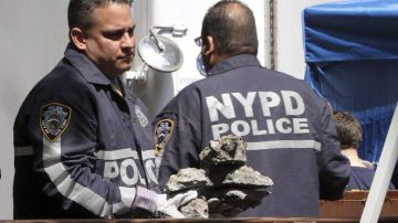 Agentes del FBI y policías de Nueva York cargan cuidadosamente los trozos de concreto y los colocan en un contenedor fuera del edificio.