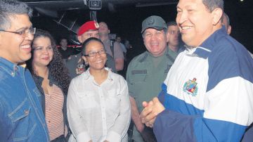 El presidente Hugo Chávez aparece sonriente rodeado de algunos  de sus ministros a su llegada al aeropuerto de Maiquetia donde no habló con la prensa.