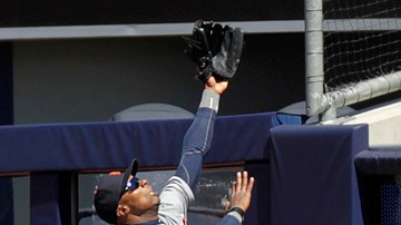 Austin Jackson trata de capturar la bola del jonrón de Granderson.