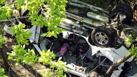 Policias investigan el van destruido después de haberse precipitado por un barranco, cuando venía por la Bronx River Parkway, ayer, en Nueva York.