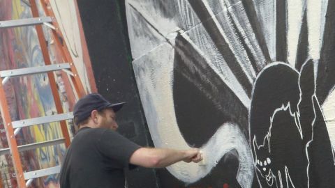 Artista realiza un mural en callejón de San Francisco.