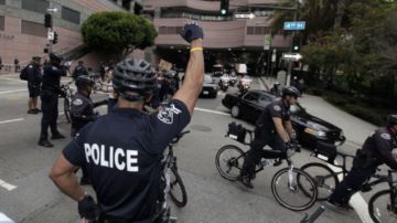 Un policía hace señales a otros oficiales durante una manifestación del Primero de Mayo en Los Ángeles.