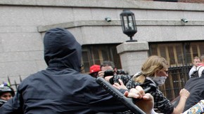 Un policía neoyorquino en momentos en que trata de golpear a uno de los manifestantes en Wall Street con su porra  policial.