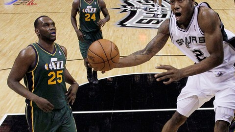 Kawhi Leonard (2), de San Antonio, trata de encestar ante la marca de Josh Howard (8) y  Al Jefferson (25), del Jazz de Utah.