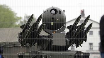 Un hombre pasa cerca de una batería de misiles Rapier. Este sistema de defensa forma parte de los ejercicios militares antes de los JO.