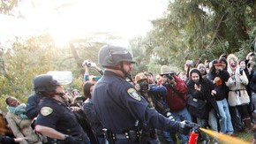 Un agente de la policía usa gas pimienta contra un grupo de estudiantes de la Universidad de California que realizan una protesta pacífica.