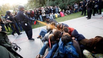 Un agente de la policía usa gas pimienta contra un grupo de estudiantes de la Universidad de California que realizan una protesta pacífica.