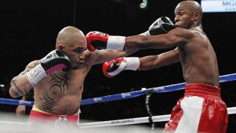 Miguel Cotto (izq.) y Floyd Mayweather Jr. intercambian golpes en el primer round de la pelea estelar por el título súper  welter disputada en la Grand Garden Arena del MGM.