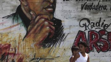 Un niño pasa al lado de un mural del presidente venezolano Hugo Chávez, en Caracas.