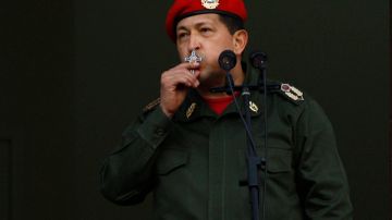 El presdiente Hugo Chávez besa un crucifijo cuando saluda a sus partidarios desde un balcón de Miraflores, en Caracas.