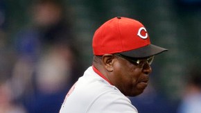 Dusty Baker (izq.)  agradece a Joey Votto después que el primera base definiera la victoria para los Rojos ante los Cerveceros.