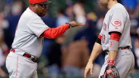 Dusty Baker (izq.) agradece a Joey Votto después que el primera base definiera la victoria para los Rojos ante los Cerveceros.
