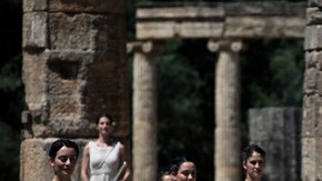La sacerdotisa (der.) enciende la flama olímpica utilizando un espejo concavo, ayer, en el último ensayo para la gran ceremonia de hoy.