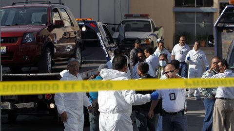 Expertos forenses bajan los dos vehículos donde fueron hallados los cuerpos de 15 personas cerca de Guadalajara, México.
