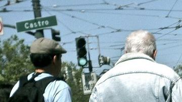 Póster y peatones en el famoso barrio homosexual de Castro en San Francisco.