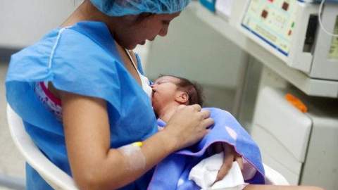Yulexis una joven de 17 años y que acaba de ser madre de su segundo hijo en Caracas lo amamanta en una sala de incubadoras para bebés prematuros.