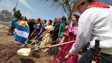 Ceremonia del 'rompimiento de tierra'  donde el Concejal  Ed P. Reyes (c), empuña  una pala junto con bailarines hondureños.