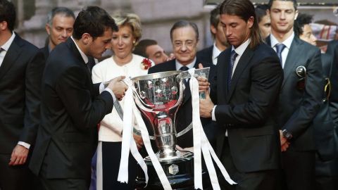 El guardameta y capitán del Real Madrid, Iker Casillas, y el defensa Sergio Ramos (d), en presencia de la presidenta regional Esperanza Aguirre, con el trofeo de ganadores de la Liga 2011-12.