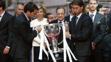 El guardameta y capitán del Real Madrid, Iker Casillas, y el defensa Sergio Ramos (d), en presencia de la presidenta regional Esperanza Aguirre, con el trofeo de ganadores de la Liga 2011-12.