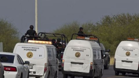 La policía federal escolta a los camiones de forenses con decenas de cuerpos, algunos de ellos mutilados, encontrados en una carretera en la ciudad de San Juan, cerca de Monterrey, México.