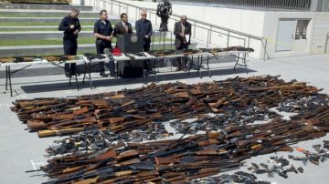 Las casi 1,700 armas decomisadas son mostradas a la prensa por las autoridades, incluyendo al alcalde y al jefe de LAPD.